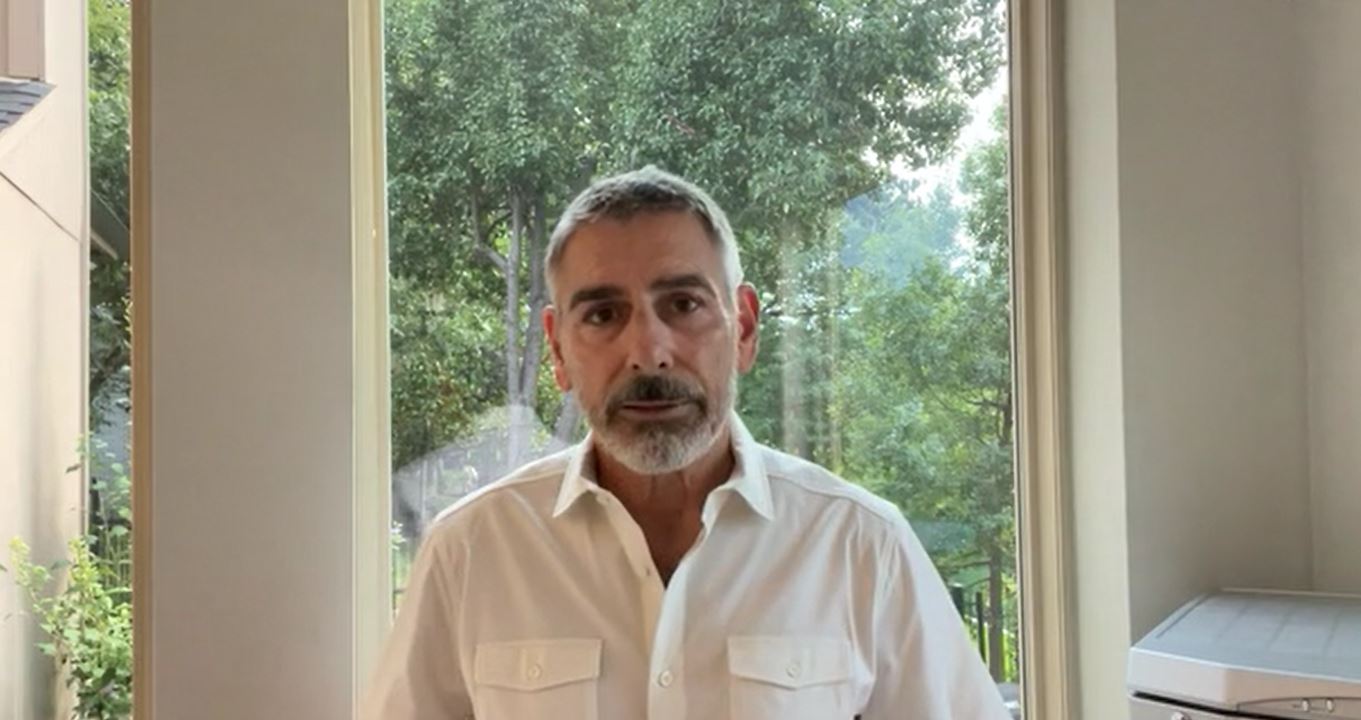 Man in white shirt standing by window